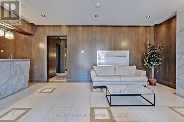 Toronto (Banbury-Don Mills) condo for rent - A living room with a white couch and a glass coffee table.