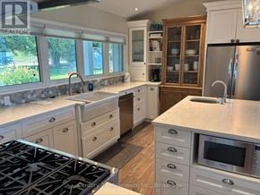 Meaford apartment for rent - A kitchen with a stove top oven and a refrigerator.