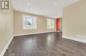 Brampton (Madoc) apartment for rent - A spacious room with wooden flooring and a large window.