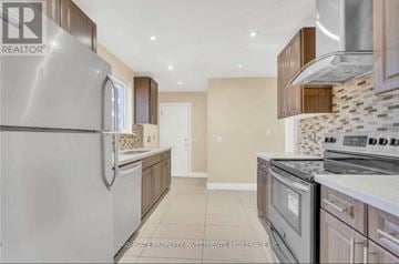 Brampton (Madoc) apartment for rent - A modern kitchen with a stainless steel refrigerator and a tiled backsplash.