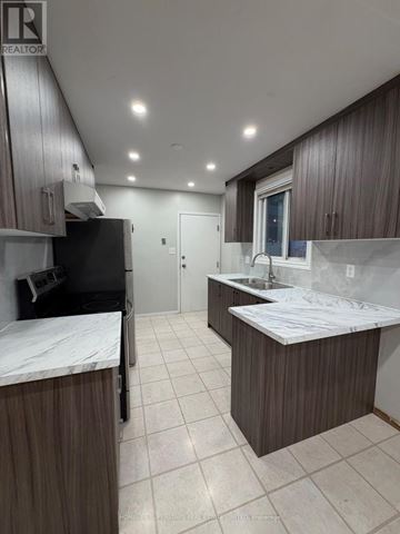 Waterloo apartment for rent - A kitchen with brown cabinets and a black fridge.