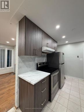 Waterloo apartment for rent - A kitchen with a black refrigerator and wooden cabinets.