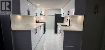 Brampton (Westgate) apartment for rent - A kitchen with white cabinets and a black refrigerator.