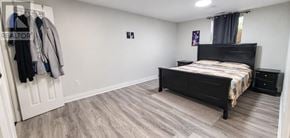 Brampton (Westgate) apartment for rent - A bedroom with a bed, nightstand, and coat rack.