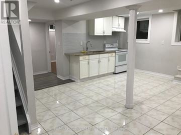 Brampton (Heart Lake West) apartment for rent - A kitchen with white cabinets and a white tile floor.