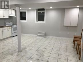 Brampton (Heart Lake West) apartment for rent - A white tiled kitchen with a dining table and chairs.