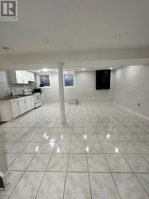 Brampton (Heart Lake West) apartment for rent - A large, empty kitchen with white tile flooring and white cabinets.