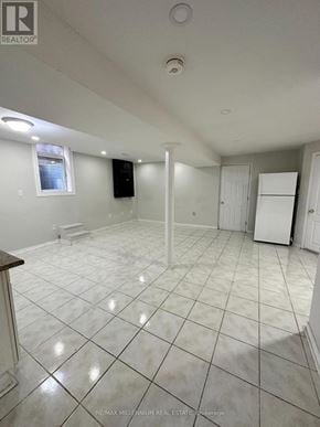 Brampton (Heart Lake West) apartment for rent - A large empty room with white tile flooring and white walls.
