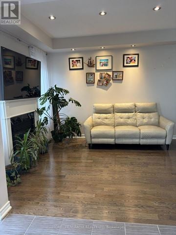 Caledon townhouse for rent - A living room with a white couch and a fireplace.