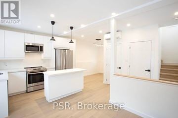 Toronto (Palmerston-Little Italy) apartment for rent - A modern kitchen with white cabinets and a central island.