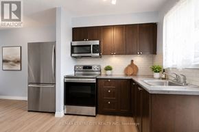 London East (East A) townhouse for rent - A kitchen with a refrigerator, oven, microwave, and sink.