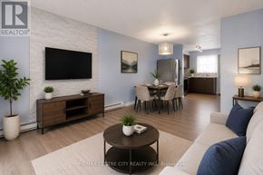 London East (East A) townhouse for rent - A living room with a white couch, a wooden coffee table, and a flat-screen TV mounted on the wall.