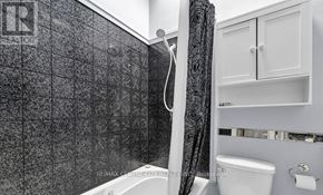London East (East A) townhouse for rent - A bathroom with a black tiled shower area and white fixtures.