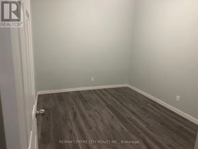 London East (East K) multi-family for rent - A room with a wooden floor and a white door.