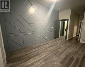 London East (East K) multi-family for rent - A room with wooden flooring and a grey wall with a diamond pattern.