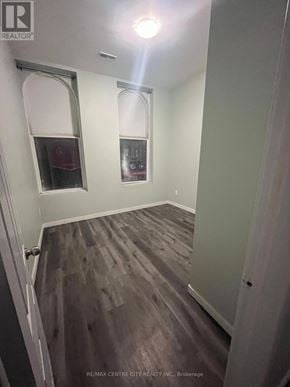 London East (East K) multi-family for rent - A room with wood flooring and a window with a red curtain.