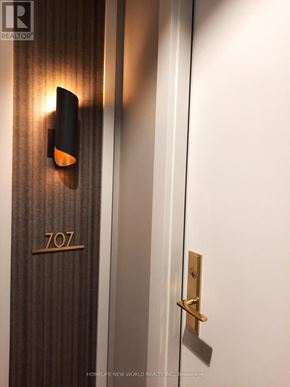 Toronto (Annex) condo for rent - A door with a gold handle and a black light on the wall.