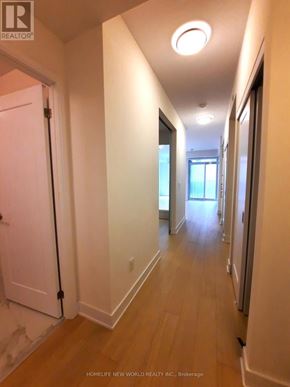 Toronto (Annex) condo for rent - A long hallway with a door on the left and a window on the right.