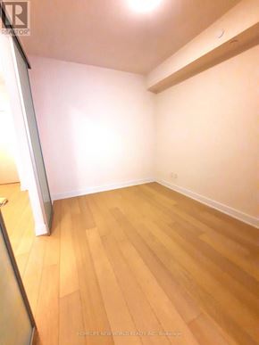 Toronto (Annex) condo for rent - A room with wooden flooring and white walls.
