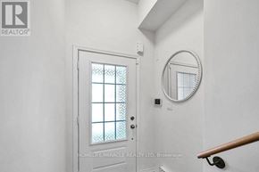 Oshawa (Windfields) townhouse for rent - A white door with a glass window and a round mirror on the wall.