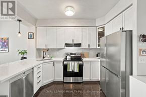 Toronto (Long Branch) condo for rent - A white kitchen with a black stove top oven.