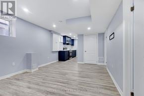 Brampton (Northwest Brampton) apartment for rent - A spacious room with light grey walls and a wooden floor.