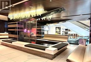 Toronto (Victoria Village) condo for rent - A modern reception area with a glass wall and a water feature.
