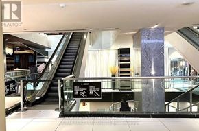 Toronto (Victoria Village) condo for rent - A lobby with a staircase and a glass railing.