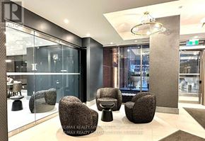 Toronto (Victoria Village) condo for rent - A modern waiting area with glass walls and black furniture.