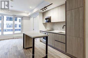 Toronto (Waterfront Communities) condo for rent - A kitchen with a table and chairs in front of a window.