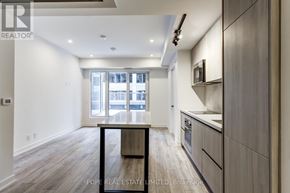 Toronto (Waterfront Communities) condo for rent - A modern kitchen with wooden floors and a dining table.