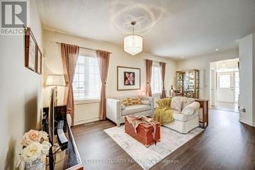 Oakville (Sh Sixteen Hollow) apartment for rent - A living room with a white couch and a red ottoman.