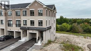 Whitby townhouse for rent - A large building with a lawn in front of it.