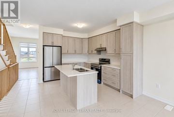 Whitby townhouse for rent - A kitchen with a refrigerator, stove, and sink.
