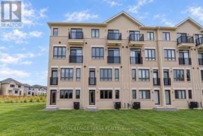 Whitby townhouse for rent - A large apartment building with balconies and a grassy area in front.