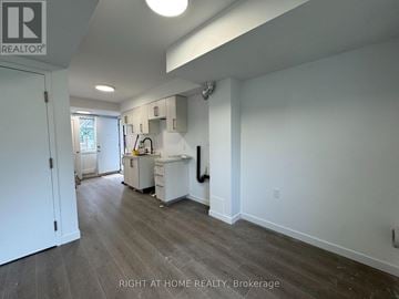 Welland (Broadway) townhouse for rent - A kitchen area with a white fridge, sink, and cabinets.