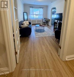 Toronto (Leaside) apartment for rent - A living room with a couch, a coffee table, and a television.