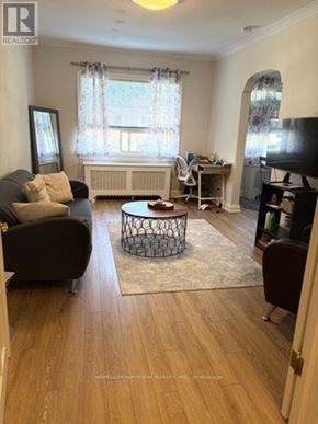 Toronto (Leaside) apartment for rent - A living room with a black couch, a coffee table, and a television.