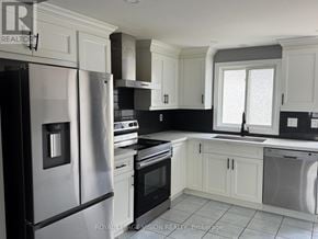 Barrie (Grove East) apartment for rent - A kitchen with white cabinets and a black refrigerator.