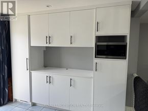 Barrie (Grove East) apartment for rent - A white cabinet with a microwave built into it.