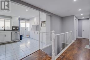 Barrie (Grove East) apartment for rent - A spacious room with white railings and wooden floors.