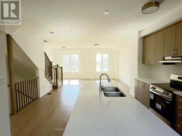Markham townhouse for rent - A modern kitchen with a sink and stove top oven.