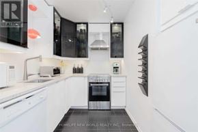 Toronto (Bay Street Corridor) condo for rent - A modern kitchen with white appliances and a black oven.
