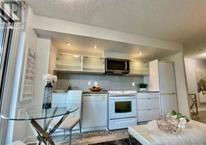 Toronto (Waterfront Communities) condo for rent - A kitchen with white appliances and a glass table.