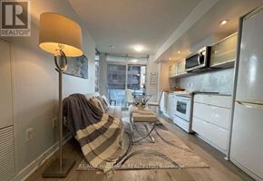 Toronto (Waterfront Communities) condo for rent - A well-lit kitchen with white appliances and a grey area rug.