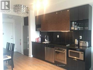 Toronto (Banbury-Don Mills) condo for rent - A modern kitchen with dark wood cabinets and stainless steel appliances.