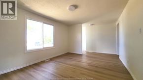 Windsor apartment for rent - A room with wooden floors and white walls, with a window on the left side.