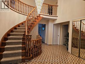 Toronto (Steeles) apartment for rent - A staircase with a wooden banister and a chandelier hanging from the ceiling.