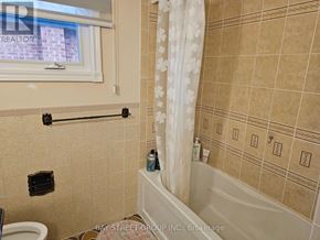 Toronto (Steeles) apartment for rent - A bathroom with beige tiles and a white bathtub.