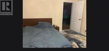 Toronto (Steeles) apartment for rent - A bedroom with a bed and a doorway leading to another room.